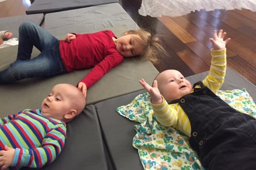 Babyn och barn på madrass under knatterytmiken
