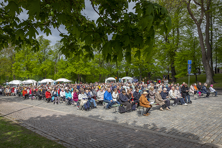 Människor sitter på Domkyrkotorget och sjunger.