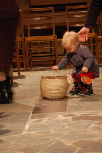 Ett barn ger kollekt i en korg i Domkyrkan.