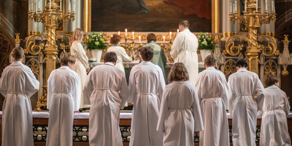 Konfirmander i albor runt altaret i Åbo domkyrka