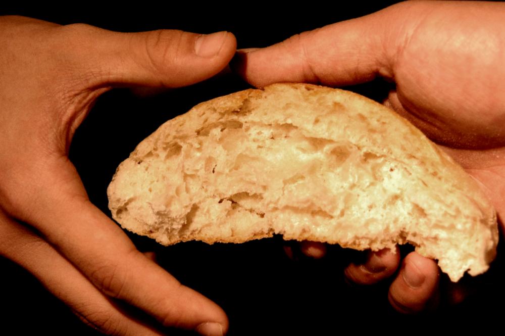 Brutet bröd i händerna på en människa